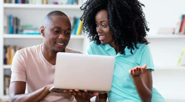 A couple is shown looking at a laptop.