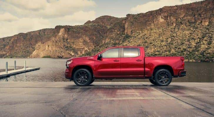 A red 2022 Chevy Silverado 1500 Z71 is shown from the side next to a lake.