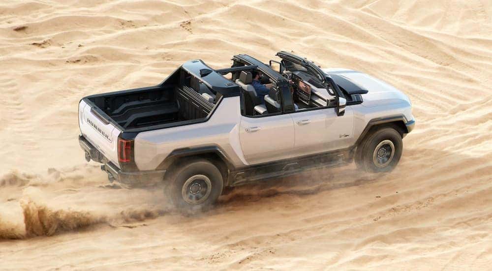 A grey 2022 GMC Hummer EV is shown from a high angle while driving through the desert.