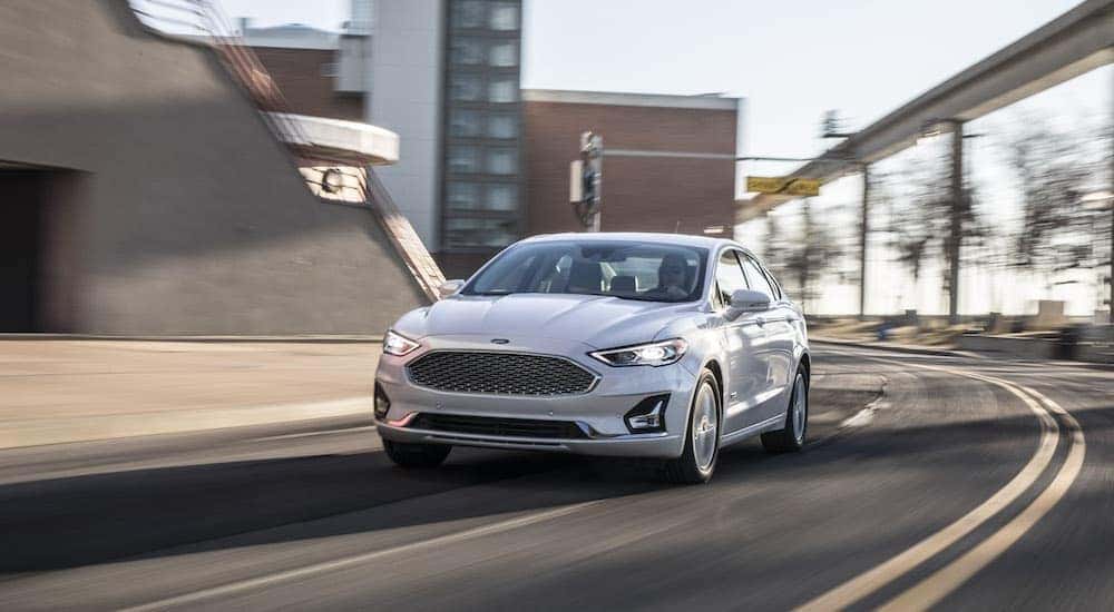 Front view of a white 2020 Ford Fusion driving from an auto dealer that handles San Jose online car sales
