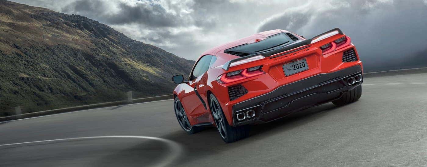 A red 2020 Chevy Corvette Stingray is shown on a mountain road after being purchased through Denver online car sales.