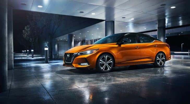 A popular vehicle for San Jose online car sales, an orange 2021 Nissan Sentra, is shown in front of a modern building.