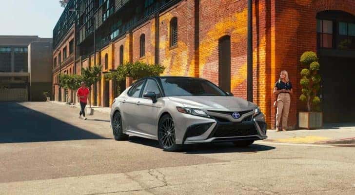 A silver 2022 Toyota Camry XSE Hybrid is shown on a city street.