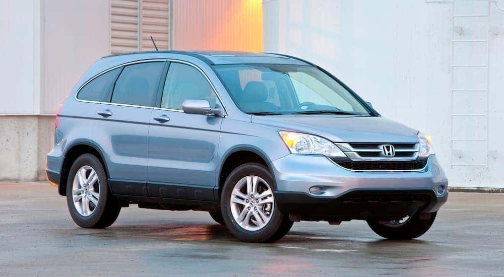 Side view of a silver Honda CR-V parked by an industrial building