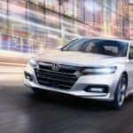 A white 2020 Honda Accord is shown from the front after leaving a dealer that handles online Honda Accord sales.