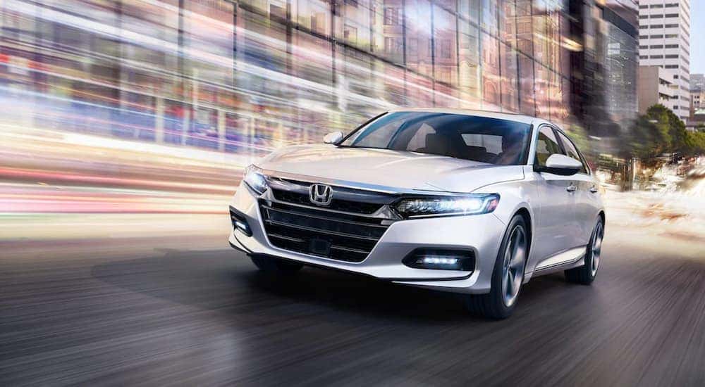 A white 2020 Honda Accord is shown from the front after leaving a dealer that handles online Honda Accord sales.