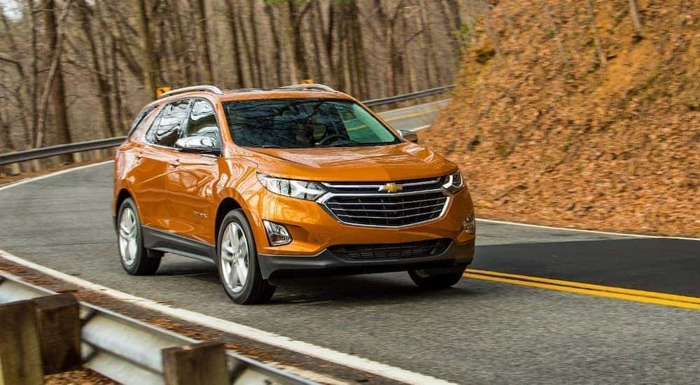 Front view of an orange 2018 Chevy Equinox driving on a mountainside road