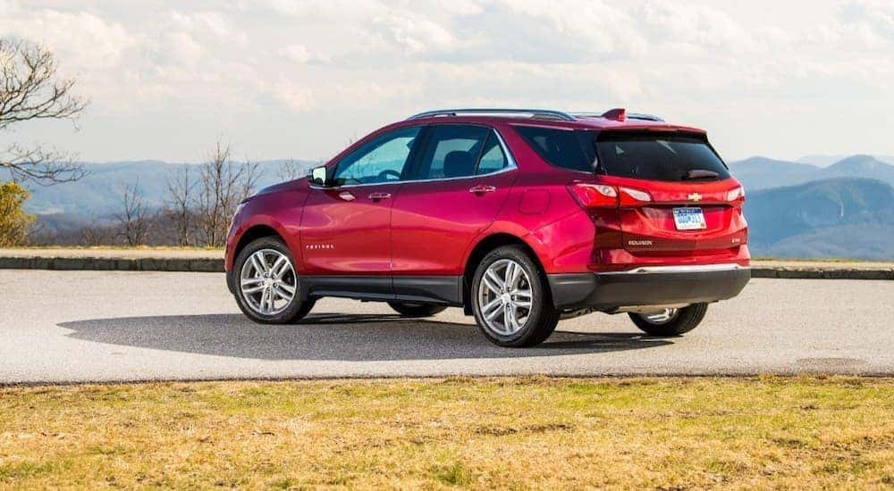 Rear angled view of a red 2020 Chevy Equinox parked in front of a mountain range