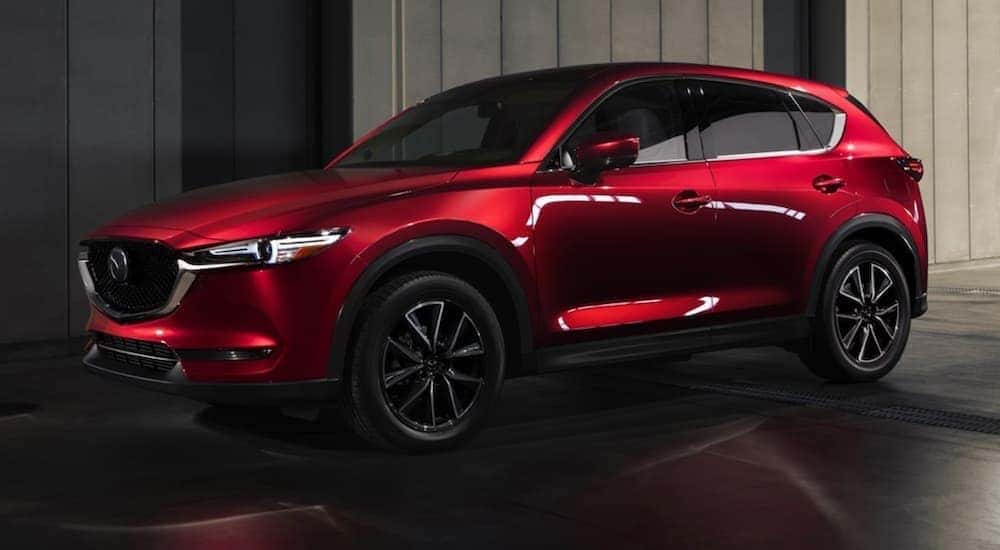 Side view of a red 2018 Mazda CX-5 in a dark showroom
