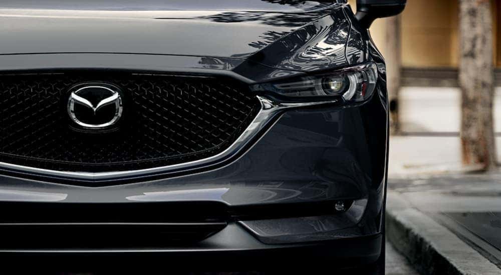 Close up of the grille on a grey 2020 Mazda CX-5 as it drives through the city