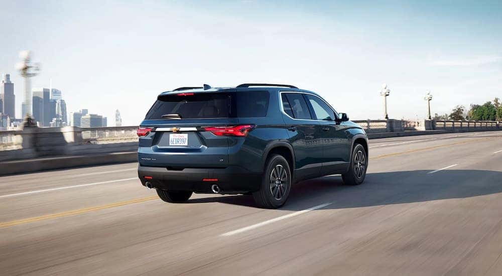 Popular with online Chevy Traverse sales, a blue 2022 Chevy Traverse is shown driving on a highway.