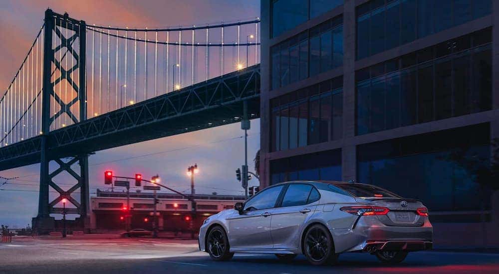 A silver 2020 Toyota Camry is shown near a city bridge after shopping New York City online car sales.