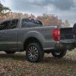 A person is shown online car shopping in the bed of a grey 2022 Ford Ranger Sport.