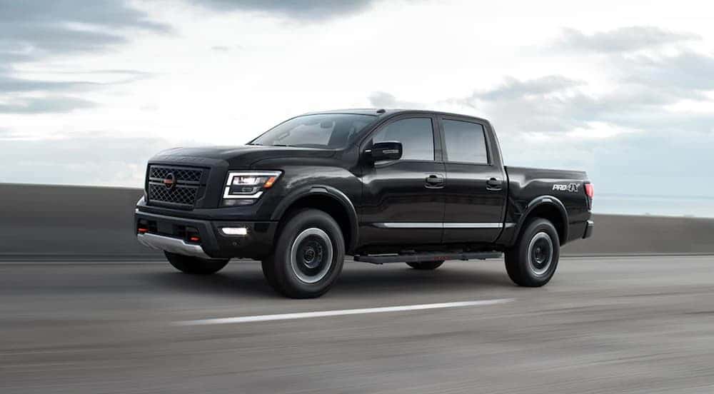 A black 2021 Nissan Titan Pro-4x is shown from the side on the highway after leaving a dealer that handles Cleveland car sales.