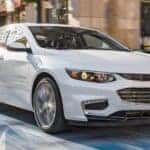 A white 2016 Chevy Malibu is shown from the front at an angle after leaving a dealer that handles Memphis car sales.