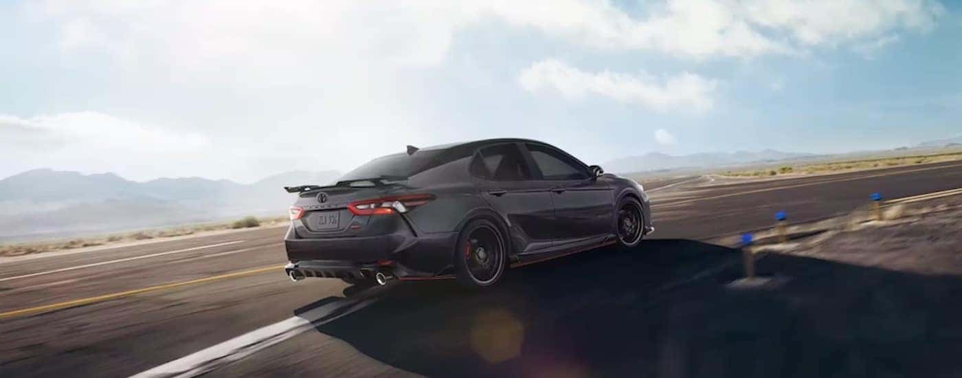 A black 2021 Toyota Camry TRD is shown from the rear at an angle.