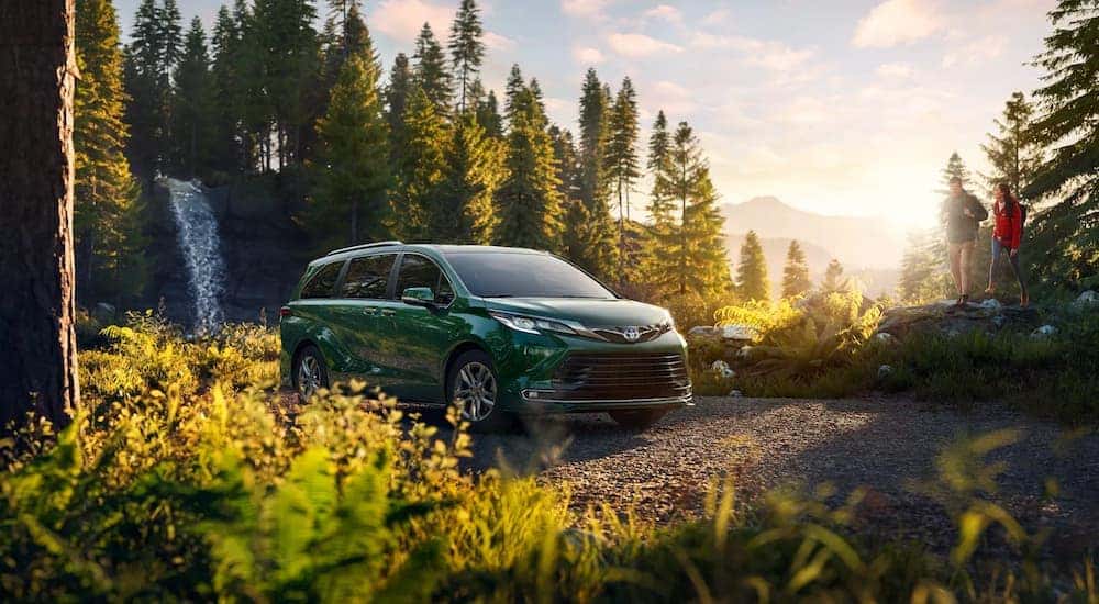 A green 2022 Toyota Sienna is shown parked near a hiking trail.