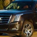 A grey 2015 Cadillac Escalade is shown parked in an empty lot.