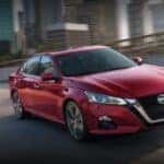 A red 2021 Nissan Altima is shown from the front at an angle after leaving a dealer that handles Des Moines car sales.