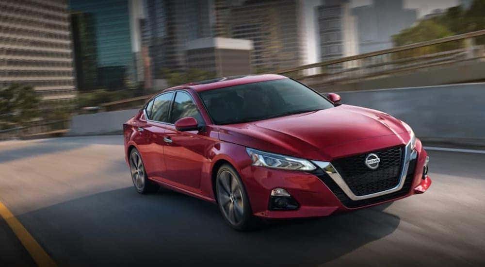 A red 2021 Nissan Altima is shown from the front at an angle after leaving a dealer that handles Des Moines car sales.