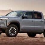 A gray 2022 Nissan Frontier Pro-4x is shown from the side while parked off-road.