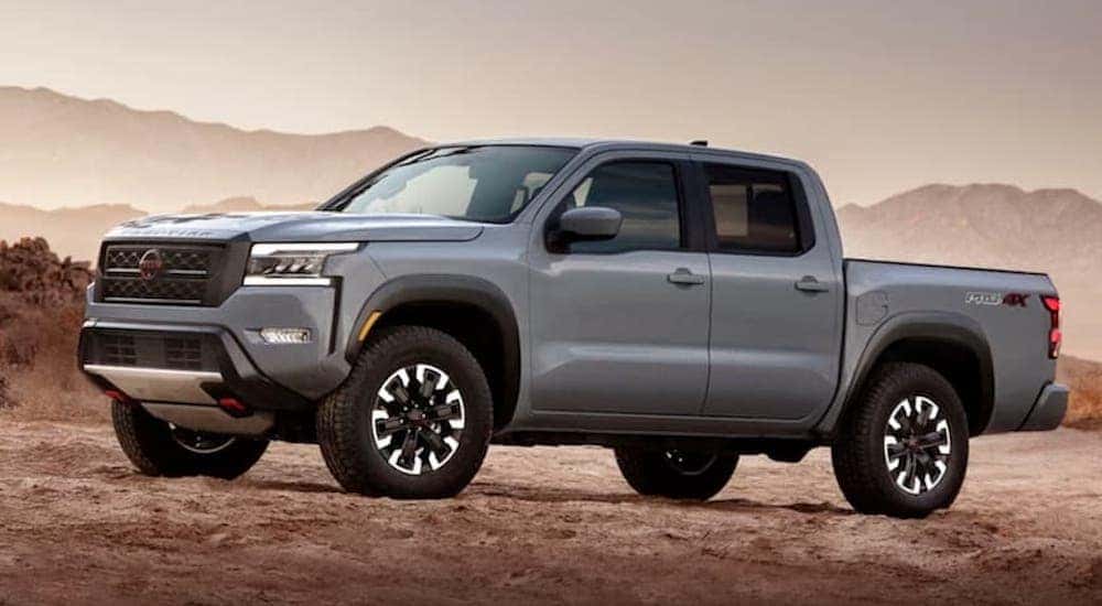 A gray 2022 Nissan Frontier Pro-4x is shown from the side while parked off-road.