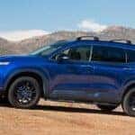 A blue 2022 Hyundai Santa Fe is shown from the side while off-road.