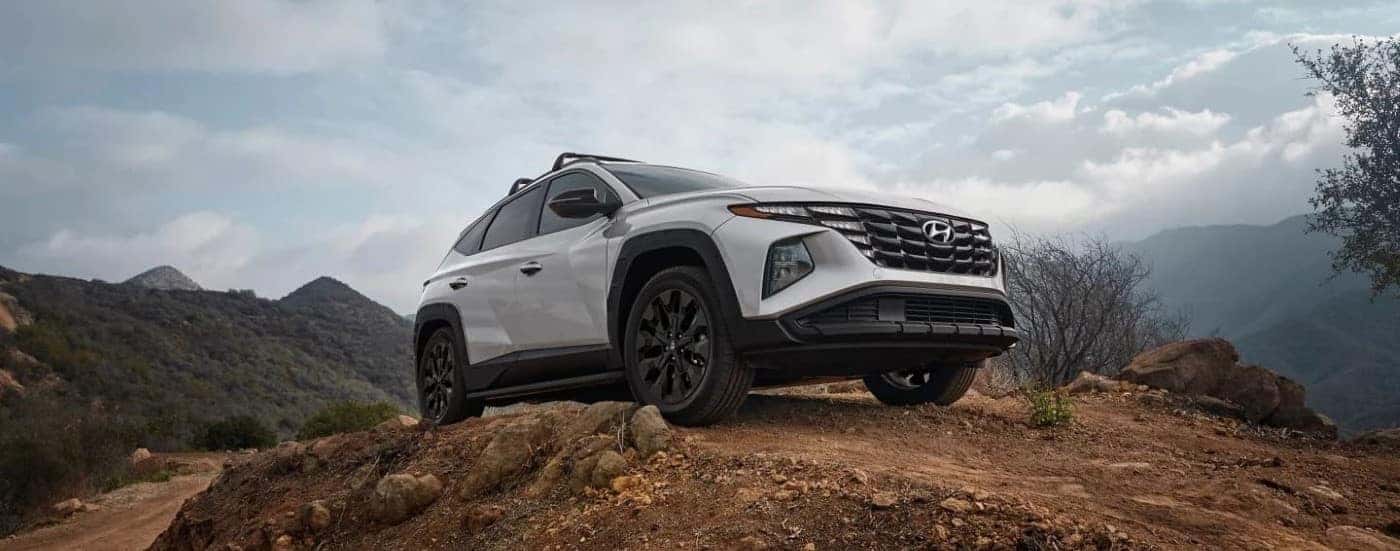 A white 2023 Hyundai Tucson XRT is shown off-roading.