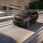 A brown 2022 Chevy Tahoe is shown from the front at an angle after leaving a dealer that has cars for sale in Omaha.