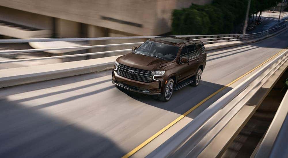 A brown 2022 Chevy Tahoe is shown from the front at an angle after leaving a dealer that has cars for sale in Omaha.