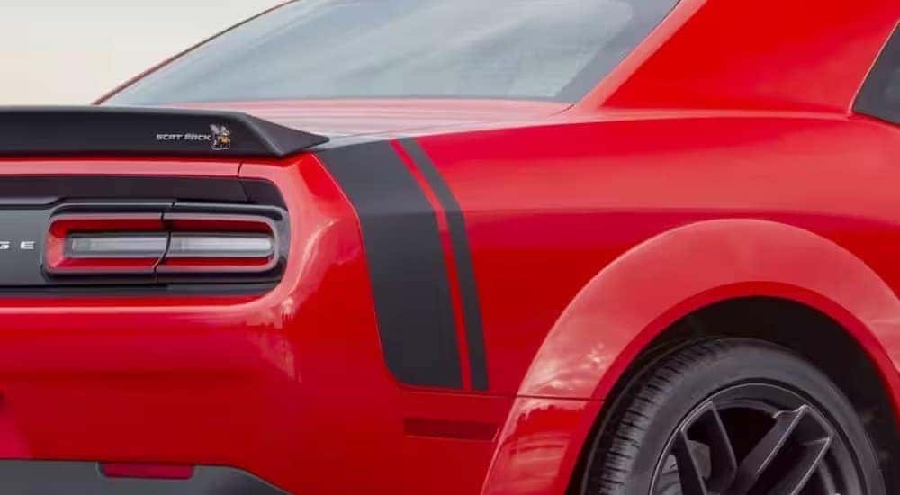 A red 2023 Dodge Challenger Scat Pack is shown from the rear at an angle after leaving a dealer that has cars for sale in Little Rock.