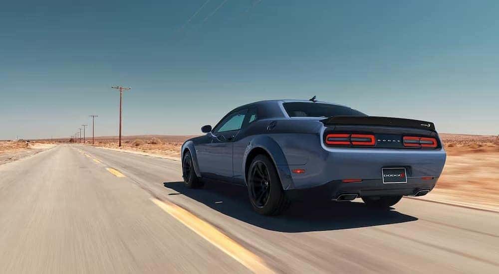 A blue 2023 Dodge Challenger Scat Pack is shown from the rear at an angle.