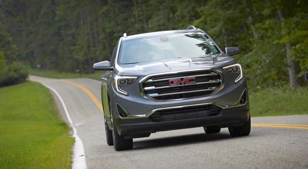 A grey 2019 GMC Terrain is shown driving on an open road.