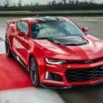 A red 2017 Chevy Camaro ZL1 is shown driving on a track after viewing cars for sale in Miami.
