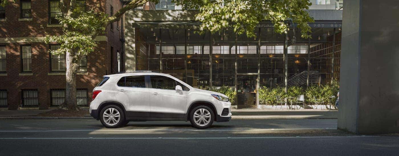 A white 2020 Chevy Trax is shown from the side on a city street.
