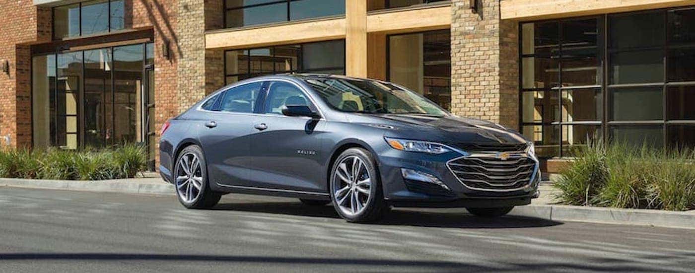 A grey 2019 Chevy Malibu is shown from the side on a city street.