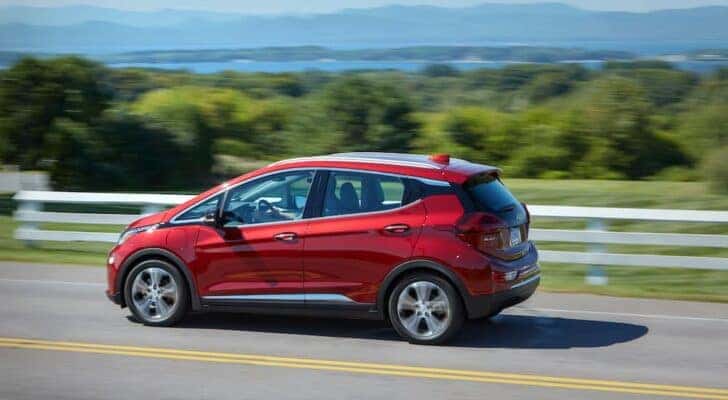 A red 2020 Chevy Bolt EV is shown from the side after leaving a dealer that has a 2020 Chevy Bolt EV for sale.