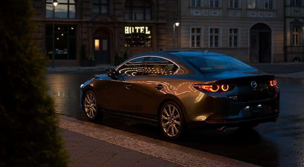 A black 2022 Mazda3 is shown from the rear at an angle after leaving a dealer that handles Fort Worth car sales.
