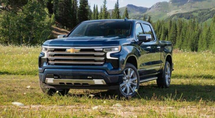 A blue 2023 Chevy Silverado 1500 High Country is shown parked on a field after viewing Fort Worth truck sales.