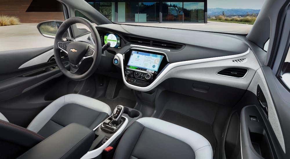 The grey and white interior of a 2020 Chevy Bolt EV is shown from the passenger seat.