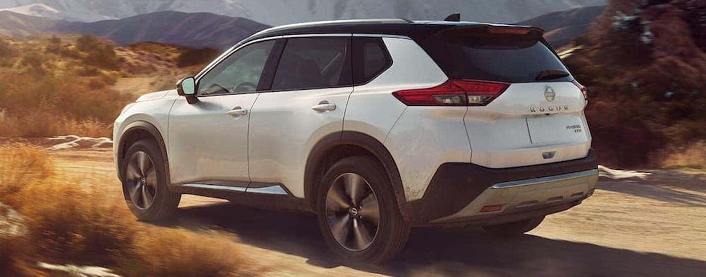 A white 2023 Nissan Rogue is shown from the rear at an angle.