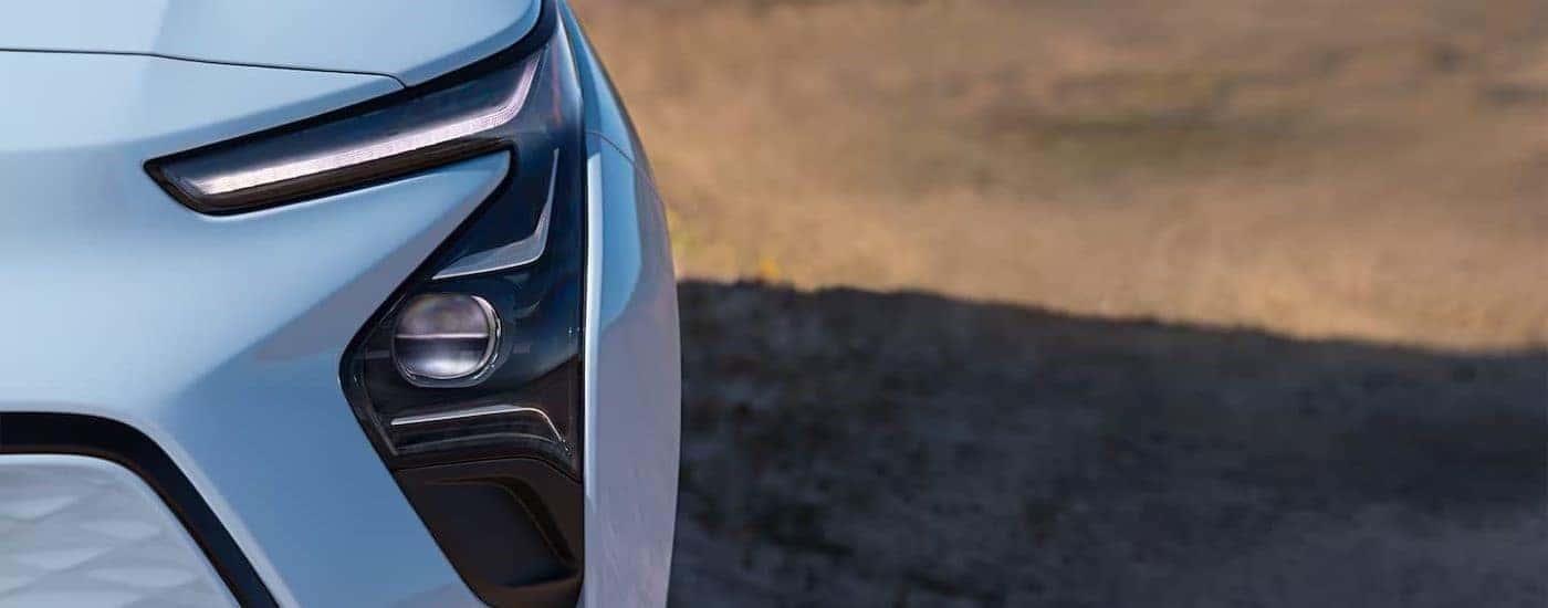 A close up shows the driver side headlight on a light blue 2022 Chevy Bolt EV.