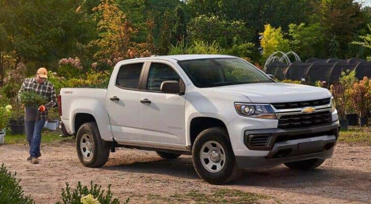 A white 2021 Chevy Colorado is shown parked near a garden.