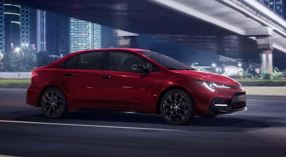 A red 2022 Toyota Corolla SE is shown driving on a city street.