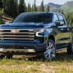 A popular Chevy Silverado 1500 for sale, a blue 2023 Chevy Silverado 1500 High Country, is shown parked on grass.