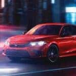 A red 2023 Honda Civic Sport is shown driving to Charleston, WV car sales.