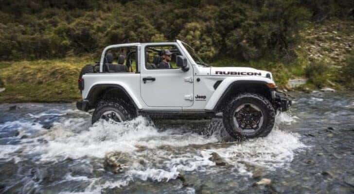 A popular 2018 Jeep Wrangler for sale, a white 2018 Jeep Wrangler Rubicon, is shown off-roading.