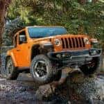 An orange 2019 Jeep Wrangler Rubicon is shown from the front at an angle after leaving a dealer that has a Jeep Wrangler for sale.
