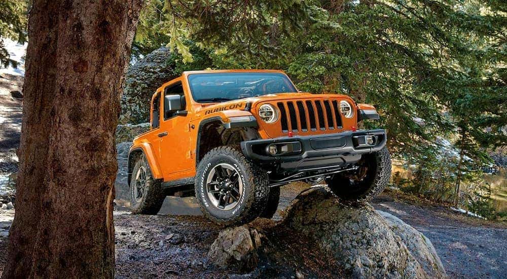 An orange 2019 Jeep Wrangler Rubicon is shown from the front at an angle after leaving a dealer that has a Jeep Wrangler for sale.