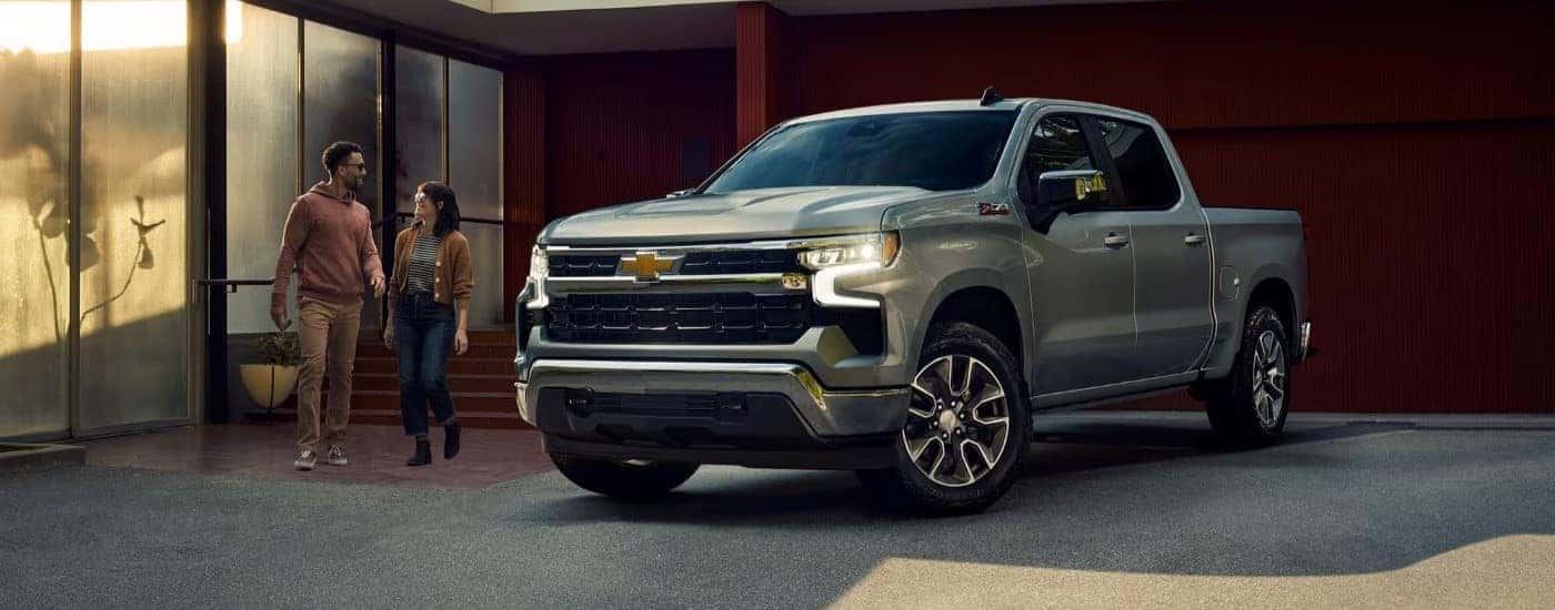 A silver 2023 Chevy Silverado 1500 Z71 is shown parked near a building.